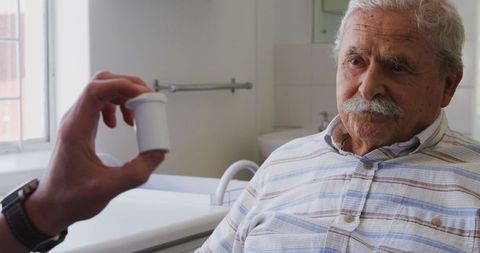 Doctor Discussing Medication with Senior Man in Hospital Room