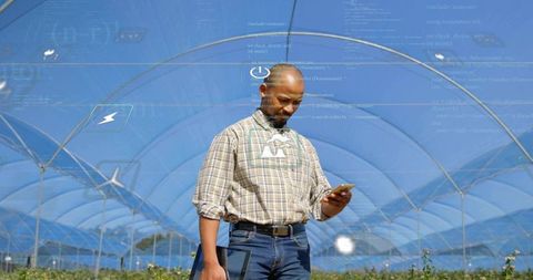 Farmer scanning crops in hoop house with smartphone and tablet using augmented reality overlays