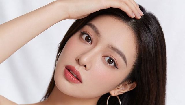 Closeup portrait of asian woman touching hair with hoop earring and soft glam beauty look