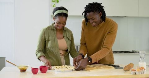 African american couple assembling lattice pie together in bright modern kitchen