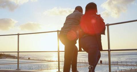 Couple Enjoying Ocean Sunset at Beachside Railing - Download Free Stock Images Pikwizard.com