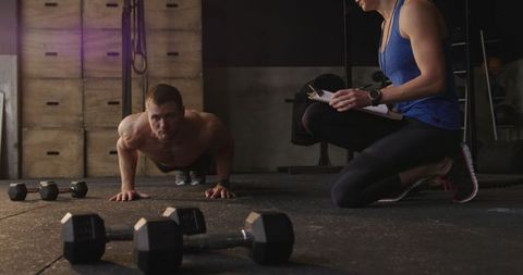 Cross Training with Personal Trainer Coaching Push-Ups in Gym