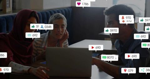 Team analyzing social media engagement on laptop with live likes and notification overlays