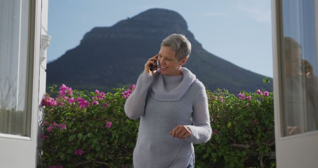 Smiling Older Woman Talking on Phone with Mountain View - Download Free Stock Images Pikwizard.com