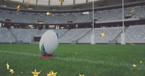 Rugby ball sitting on kicking tee awaiting kickoff in empty stadium with gold stars