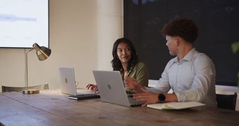 Team collaboration in office with laptops during evening meeting
