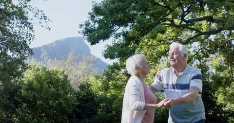 Elderly Couple Dancing Joyfully in Lush Garden Setting