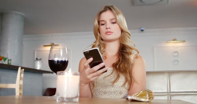 Young Woman Texting on Smartphone at Cafe with Wine and Candle - Download Free Stock Images Pikwizard.com