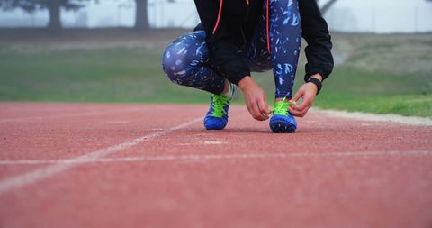 Female Athlete Tying Shoelaces on Running Track Preparation - Download Free Stock Images Pikwizard.com
