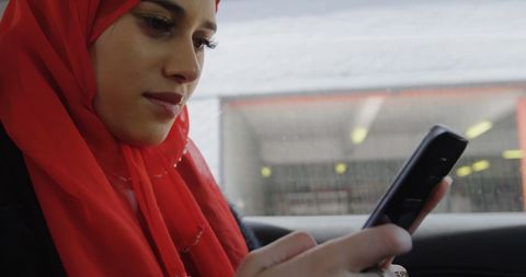 Muslim Woman in Red Hijab Using Smartphone in City Environment