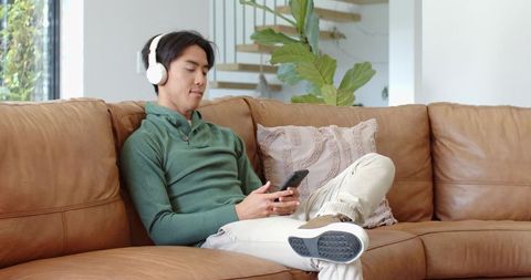 Man Relaxing with Headphones on Sofa in Minimalist Living Room