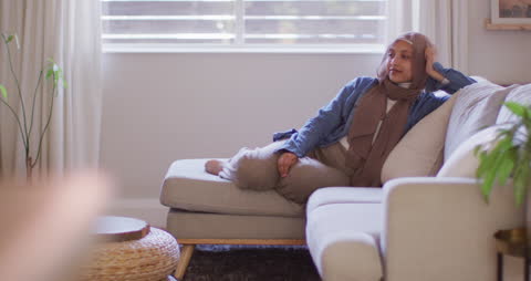 Serene Woman in Hijab Relaxing on Comfortable Sofa
