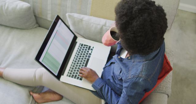 Woman Working on Laptop While Drinking Coffee on Sofa - Download Free Stock Images Pikwizard.com