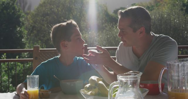 Father and son bonding over breakfast on sunny patio - Download Free Stock Images Pikwizard.com