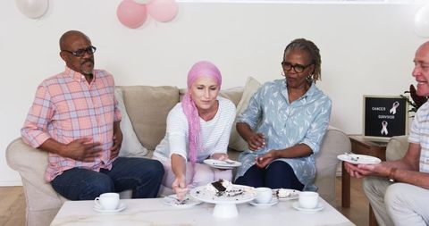 Senior Friends Sharing Cake Celebrating Life In Cozy Living Room