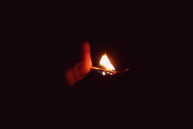 Hand Holding Burning Matchstick in Dark - Download Free Stock Photos Pikwizard.com