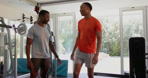 Two Men Conversing in Modern Home Gym After Workout