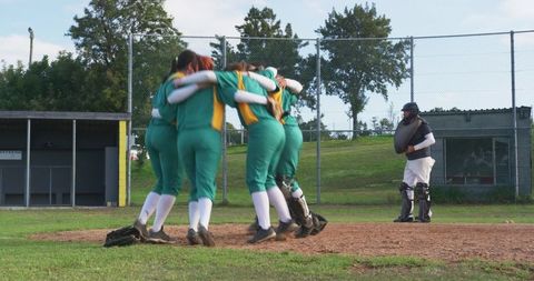 Female Softball Team Celebrating on Pitcher's Mound