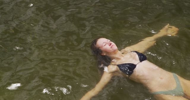 Young Woman Relaxing and Floating in Lake Wearing Bikini - Download Free Stock Photos Pikwizard.com