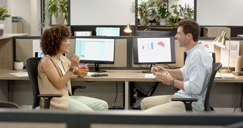 Diverse Coworker Interaction at Modern Office Desk