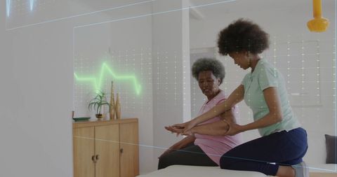 Senior woman exercising with physiotherapist and cardiograph overlay