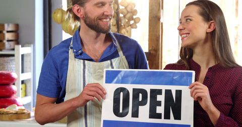 Happy Workers Holding Open Sign in Organic Shop