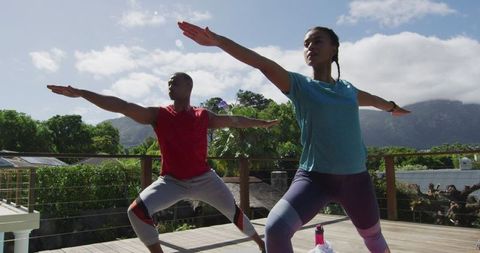 Couple Practicing Yoga Outdoors in Mountain Scenery