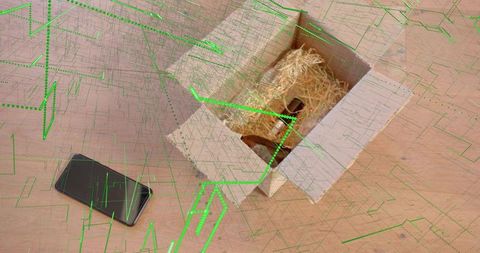Hamster peeking from straw-filled cardboard box on wooden table with smartphone and neon grid