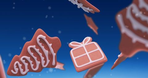 Festive gingerbread cookies with falling snowflakes on blue