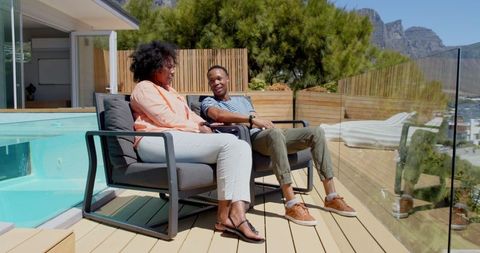 Young couple relaxing on patio overlooking scenic view