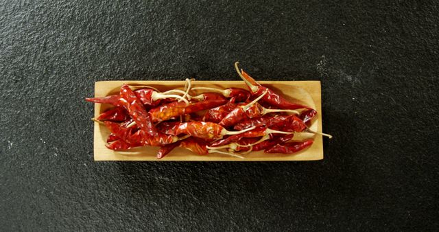 Dried chili pepper in wooden tray on black background 4k