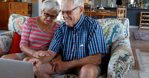 Senior couple enjoying a happy moment on laptop together