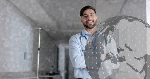 Smiling male doctor standing with arms crossed in clinic corridor with globe overlay