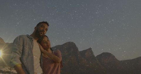 Romantic couple star gazing among majestic mountains