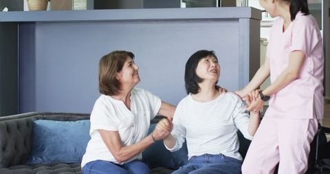 Senior Women with Multicultural Nurse and Friend in Living Room