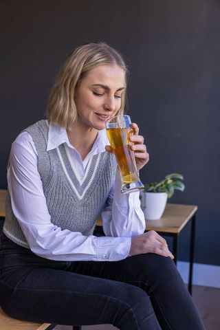 Elegant woman savoring beer in modern lounge