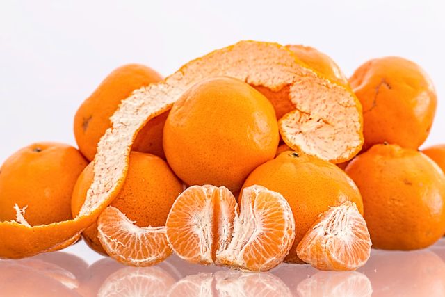 Close-up of fresh oranges with peel and juicy segments. Ideal for promoting healthy eating, vitamin C benefits, dietary visuals, and nutrition content. Perfect for food blogs, recipe articles, and health newsletters.