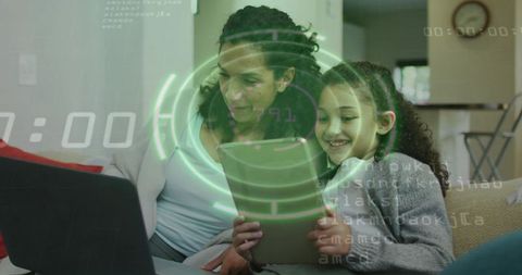 Mother and Daughter Exploring Augmented Reality Tablet Together While Using Laptop at Home