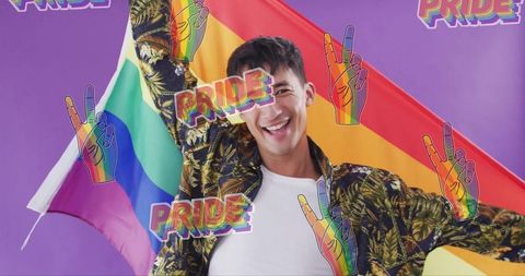 Smiling young man celebrating pride waving rainbow flag with colorful pride stickers
