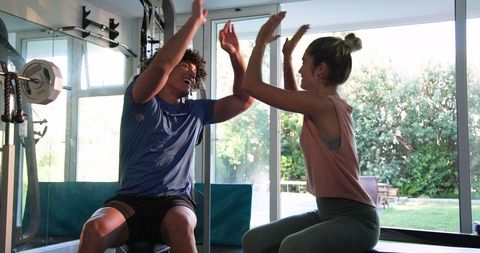 Young Couple Exercising with Dumbbells in a Gym Setting