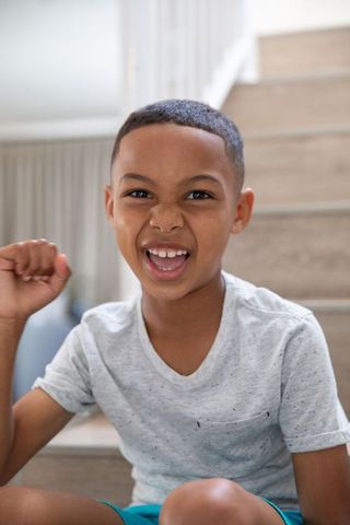 Joyful African American Boy Celebrating Victory at Home