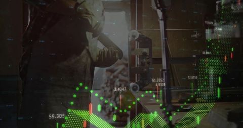 Standing industrial worker raising arms in workshop with stock market data overlay and conveyor