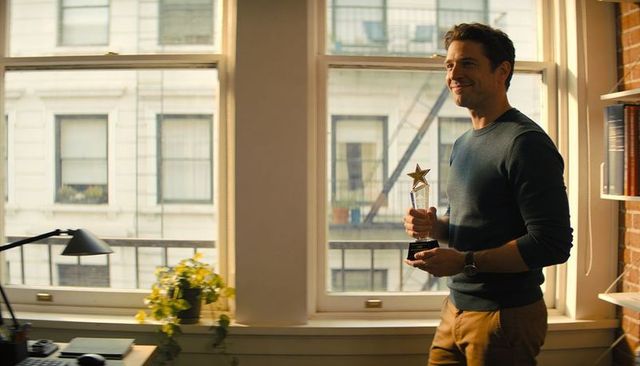 Smiling professional holding star trophy by window in modern office celebrating achievement
