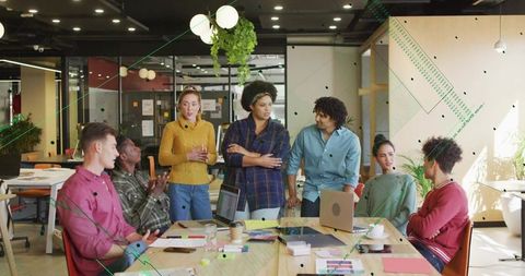Woman Leading Diverse Project Team Brainstorming in Modern Coworking Workspace with Laptops