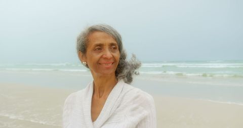 Elderly Woman Smiling Contemplatively on Beach