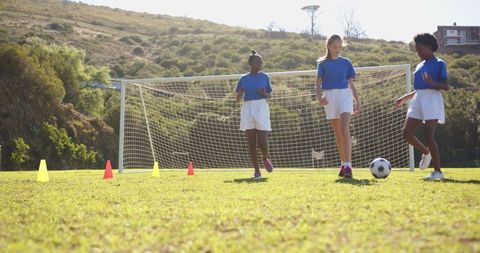 Girls Playing Soccer on School Field During Practice