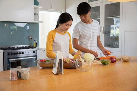 Asian Couple Cooking Healthy Meal Together in Modern Home Kitchen