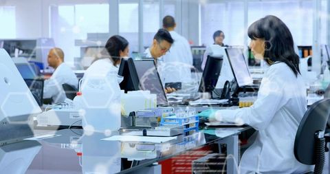 Clinical lab team handling sample trays with digital workflow, female technician at bench