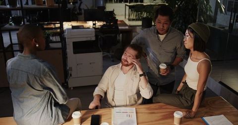 Diverse Team Collaborating at Office Desk with Charts and Coffee