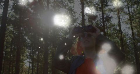 Woman Hiker with Binoculars Exploring Dense Forest